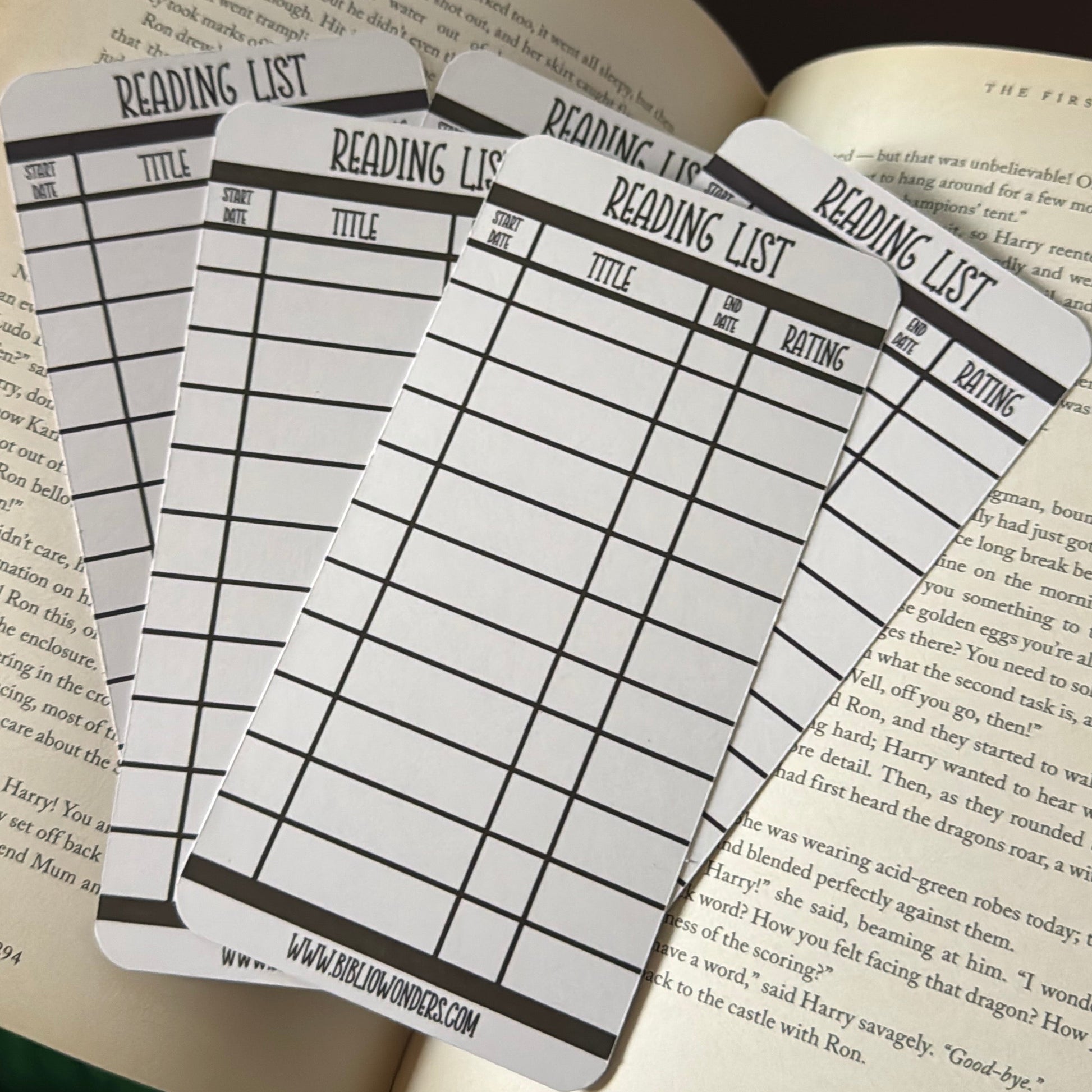 Four reading list bookmarks on an open book